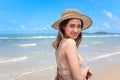 Portrait of beautiful Asian woman with big hat and sunglasses enjoy spending time on tropical sand beach blue sea, happy smiling Royalty Free Stock Photo