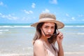 Portrait of beautiful Asian woman with big hat and sunglasses enjoy spending time on tropical sand beach blue sea, happy smiling Royalty Free Stock Photo