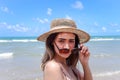 Portrait of beautiful Asian woman with big hat and sunglasses enjoy spending time on tropical sand beach blue sea, happy smiling Royalty Free Stock Photo