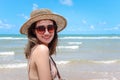 Portrait of beautiful Asian woman with big hat and sunglasses enjoy spending time on tropical sand beach blue sea, happy smiling Royalty Free Stock Photo