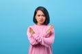 Portrait of beautiful Asian woman frowning displeased showing stop gesture, prohibiting something, expressing disapproval