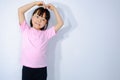 Portrait of a beautiful Asian woman with a heart-shaped hand gesture on a smiling face on a plaster background. Asian.