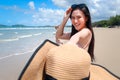 Portrait of beautiful Asian woman holding big hat and sunglasses enjoy spending time on tropical sand beach blue sea, happy Royalty Free Stock Photo