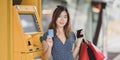 Portrait of beautiful asian woman holding credit card after withdrawing the cash from ATM machine Royalty Free Stock Photo