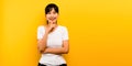 beautiful Asian woman merry, dressed in white, sitting, smiling and happy on a yellow background