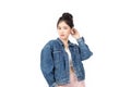 Portrait of beautiful asian woman model in white T-shirt, dressed in denim jacket posing while standing and looking at camera Royalty Free Stock Photo