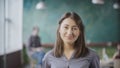 Portrait of beautiful Asian woman in modern office. Young successful businesswoman looking at camera, smiling. Royalty Free Stock Photo