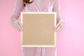 Portrait beautiful asian woman on pink background and wearing pink clothes with holding cork board, emotions action Royalty Free Stock Photo