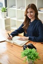 A portrait of a beautiful Asian woman sits at a table with her diary. writing diary, making notes Royalty Free Stock Photo