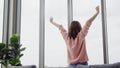 Portrait of beautiful Asian woman stretching her body and her arms after she wake up feel sleepy in her bedroom at home. Lifestyle