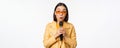 Portrait of beautiful asian woman in sunglasses, stylish girl singing, giving speech with microphone, holding mic and Royalty Free Stock Photo