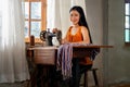 Portrait of beautiful Asian woman with traditional cloth and sit near old sewing machine and look at camera with smiling Royalty Free Stock Photo