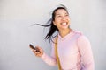 Beautiful asian woman walking outside with mobile phone and smiling Royalty Free Stock Photo