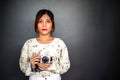 Portrait of beautiful Asian young girl student with small pocket camera outdoor at day Royalty Free Stock Photo