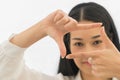 Portrait of beautiful asian young woman making frame with her fingers on white background. Focus hand Royalty Free Stock Photo