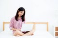 Portrait of beautiful asian young woman setting on bed using laptop computer at bedroom for leisure and relax. Royalty Free Stock Photo