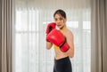 Portrait of beautiful Asian young woman in sportswear with red boxing gloves pose show punch while fitness training and exercise Royalty Free Stock Photo