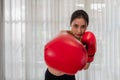 Portrait of beautiful Asian young woman in sportswear with red boxing gloves poses show punch while fitness training and exercise Royalty Free Stock Photo