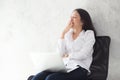 Portrait of beautiful asian young woman yawn at her work place with laptop computer on cement background. Royalty Free Stock Photo