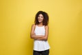 Portrait of beautiful attractive African American woman posting crossed arms with happy smiling. Yellow studio Royalty Free Stock Photo