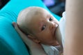 Portrait of the beautiful baby face sucking mother breast milk on blue pillow Royalty Free Stock Photo