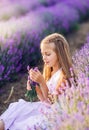 Portrait of a beautiful baby girl in a lavender field. Summer photo in purple colors