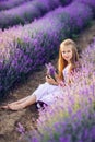 Portrait of a beautiful baby girl in a lavender field. Summer photo in purple colors