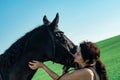 portrait of beautiful black dressage horse with his owner and rider posing in green grass meadow after training. close up Royalty Free Stock Photo