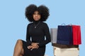 Portrait of a beautiful black girl sitting next to shopping bags and boxes, sales consitute Royalty Free Stock Photo