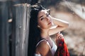 Portrait of a Beautiful black haired girl in a white vintage dress standing near wood fence.Young woman model posing in a russian Royalty Free Stock Photo