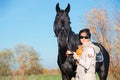 Portrait of beautiful black horse  with his owner and rider  posing in green grass meadow. autumn season Royalty Free Stock Photo