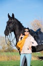 Portrait of beautiful black horse  with his owner and rider  posing in green grass meadow. autumn season Royalty Free Stock Photo