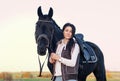 Portrait of beautiful black horse with his rider posing in green grass meadow. autumn season Royalty Free Stock Photo
