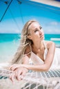 Portrait of the beautiful blond long hair bride in white dress. She lay on the blue sailboat. Blue sky and turquoise sea Royalty Free Stock Photo