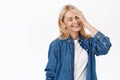 Portrait of beautiful blond senior woman, mature lady 50s years, laughing and smiling, touching healthy glowing facial Royalty Free Stock Photo