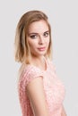 Portrait of beautiful blond sensual woman in pink cocktail dress on grey background Royalty Free Stock Photo