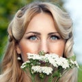 Portrait of beautiful blond woman with bouquet of bright wildflo