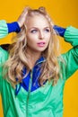 Portrait of beautiful blond woman in casual colorful vivid green summer clothes on yellow background Royalty Free Stock Photo