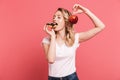 Portrait of beautiful blond woman 20s wearing casual t-shirt holding sweet donut and fresh healthy apple Royalty Free Stock Photo