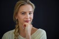 Portrait of beautiful blond young woman looking at camera and smiling on black background, close-up Royalty Free Stock Photo