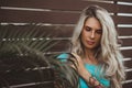 Portrait of a beautiful blonde closeup. Wearing a turquoise t-shirt. Arms tattooed. The concept of modern fashion.