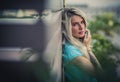 Portrait of a beautiful blonde closeup. Wearing a turquoise t-shirt. Arms tattooed. The concept of modern fashion.