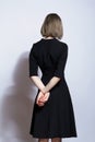 Portrait of beautiful blonde female in black dress from back side Royalty Free Stock Photo