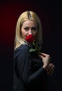 Portrait of a beautiful blonde girl with a red rose in her hand Royalty Free Stock Photo