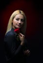 Portrait of a beautiful blonde girl with a red rose in her hand Royalty Free Stock Photo