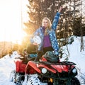 Beautiful blonde girl with red ATV in winter in the mountains Royalty Free Stock Photo