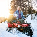 Beautiful blonde girl with red ATV in winter in the mountains Royalty Free Stock Photo