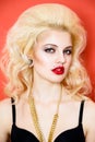 Portrait of beautiful blonde glam rocker woman on orange background. Royalty Free Stock Photo