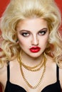 Portrait of beautiful blonde glam rocker woman on orange background. Royalty Free Stock Photo