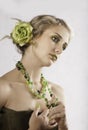 Portrait of beautiful blonde in green with beaded necklace